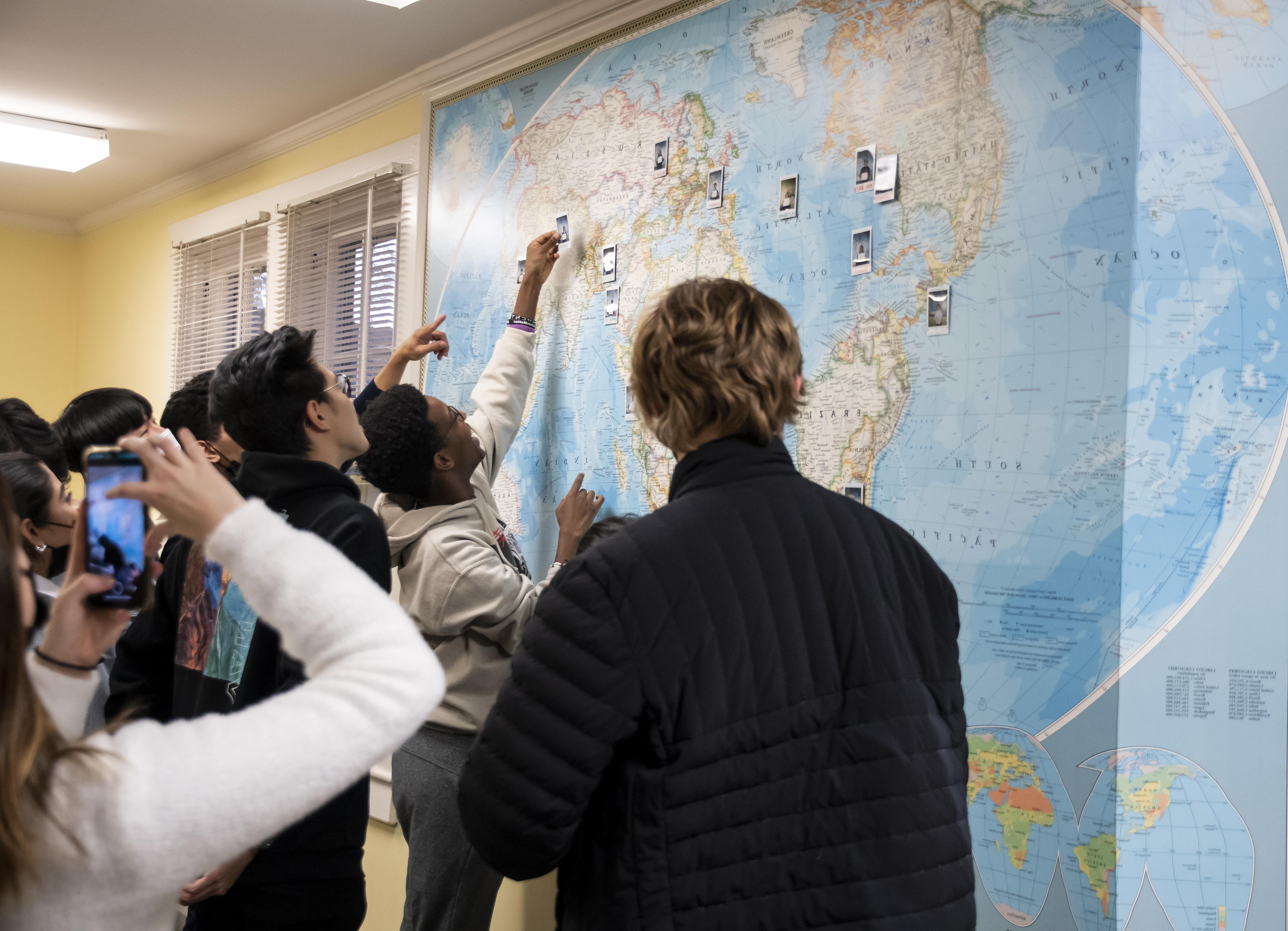 世界厕所GEO的成员们看着一张挂着照片的地图